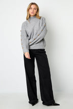 Trui met knopen op de mouwen